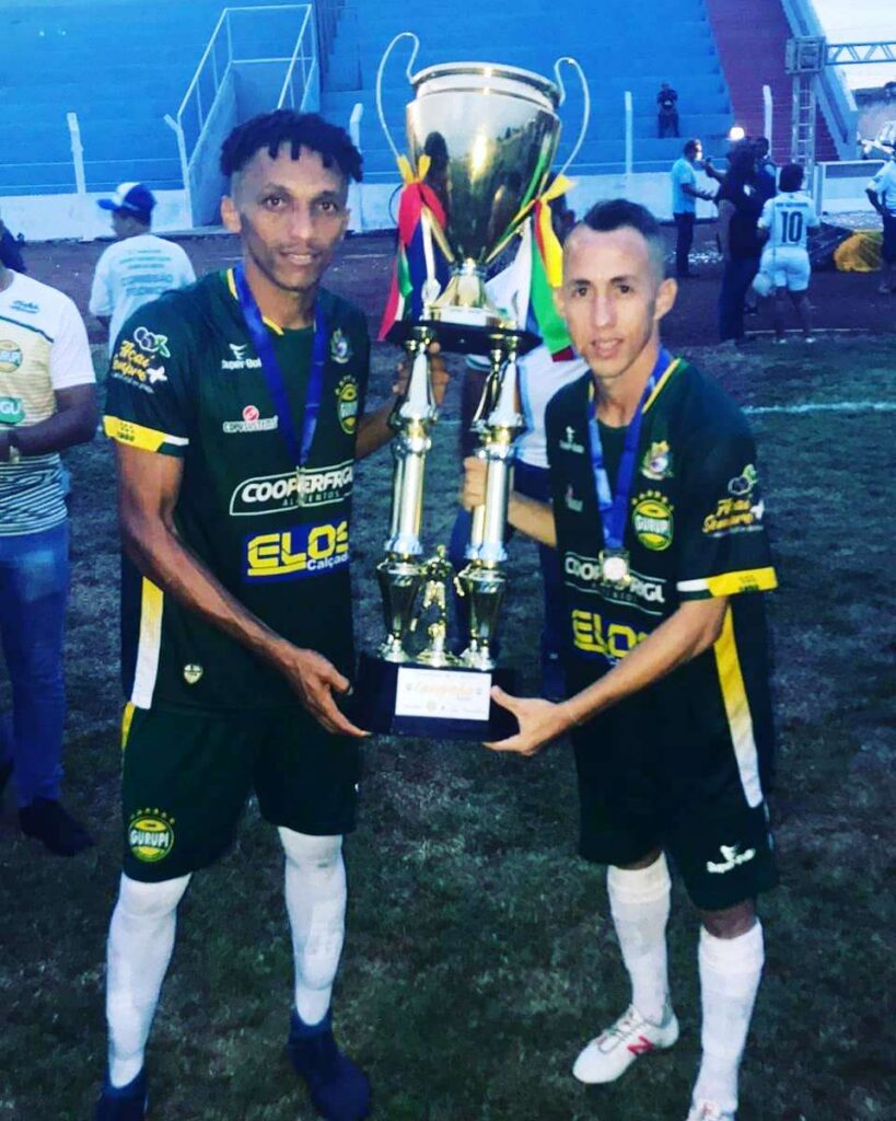 Dudu segura o troféu com o companheiro de clube, o atacante Tety 