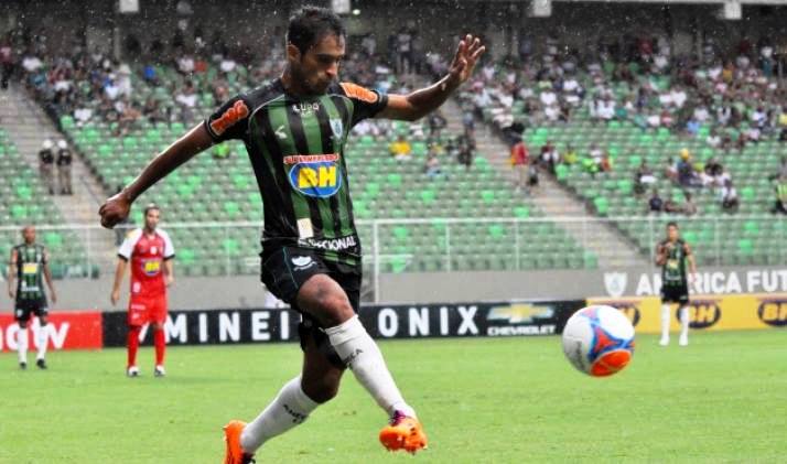 Meia-atacante Tchô durante disputa de lance com a camisa do América Mineiro 